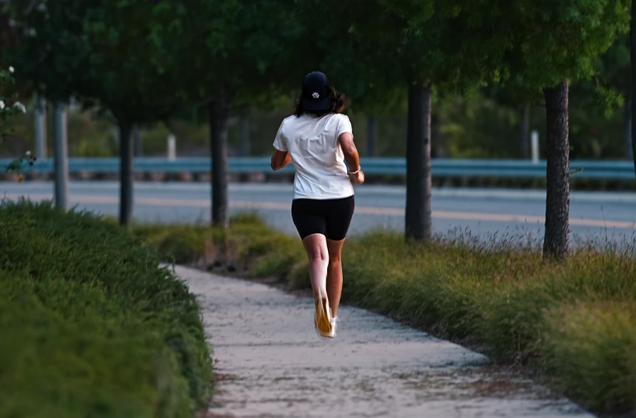 Runner heading down a quiet tree-lined path.